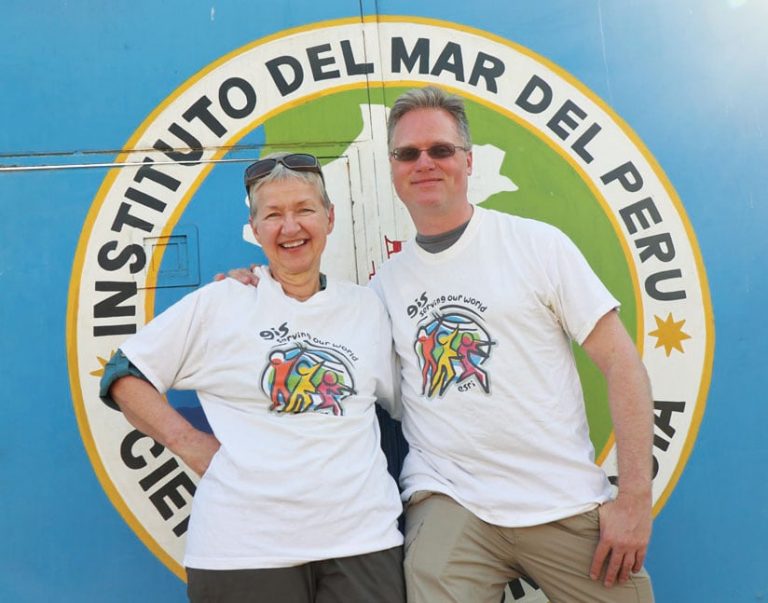 A man and a woman wearing Esri T-shirts stand next to each other in front of a sign