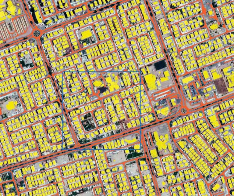 Satellite imagery of a neighborhood in Kuwait City with the streets marked by red lines and the building footprints denoted in yellow