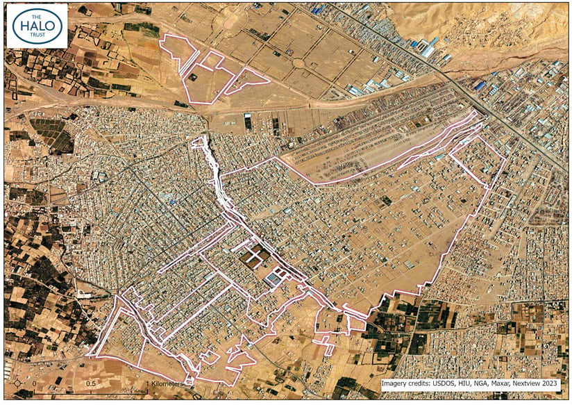 An in-color aerial image of land that shows more development in the area, including in the formerly undeveloped areas surrounded by white polygons, which have more buildings in them