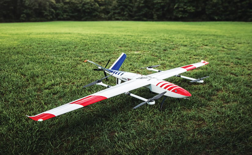 A red, white, and blue drone parked in the grass