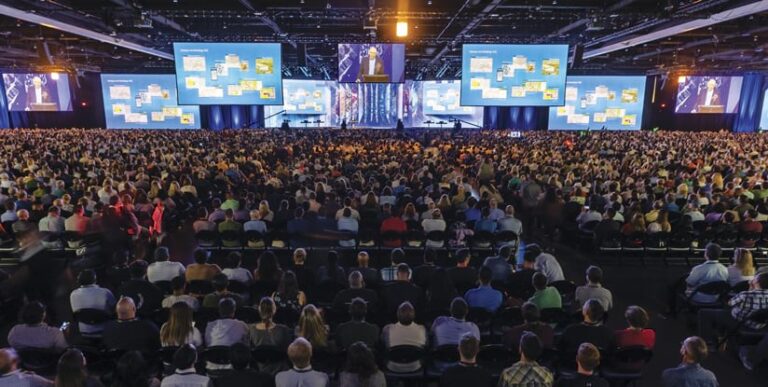 Thousands of people watch Jack Dangermond present on the Plenary stage amid more than a half dozen screens