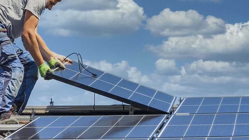 A worker installs a solar panel