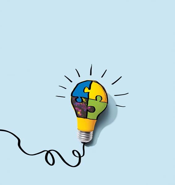 A yellow lightbulb with a black cord has puzzle pieces drawn on it in blue, green, and yellow, illustrating the concept of problem solving.