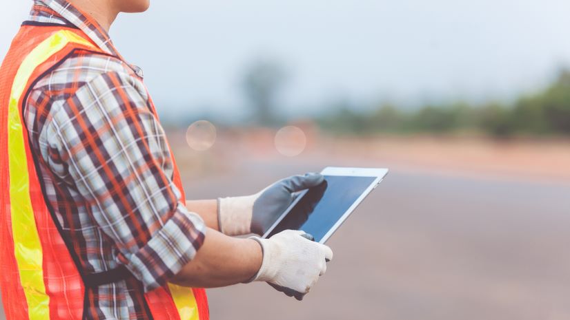 A field worker collects data near the runway.