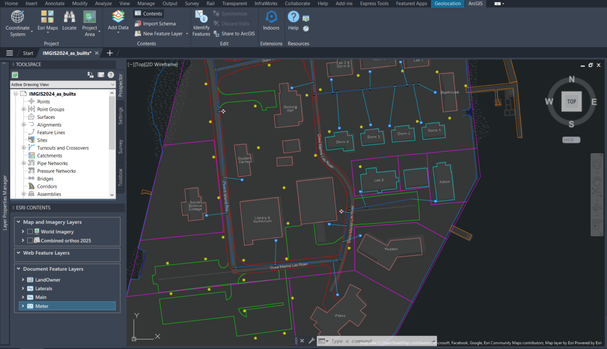 A screenshot of the ArcGIS for AutoCAD plug-in within Autodesk AutoCAD showing a 2D map of buildings on a campus with colorful lines overlaid to denote roads and utilities.