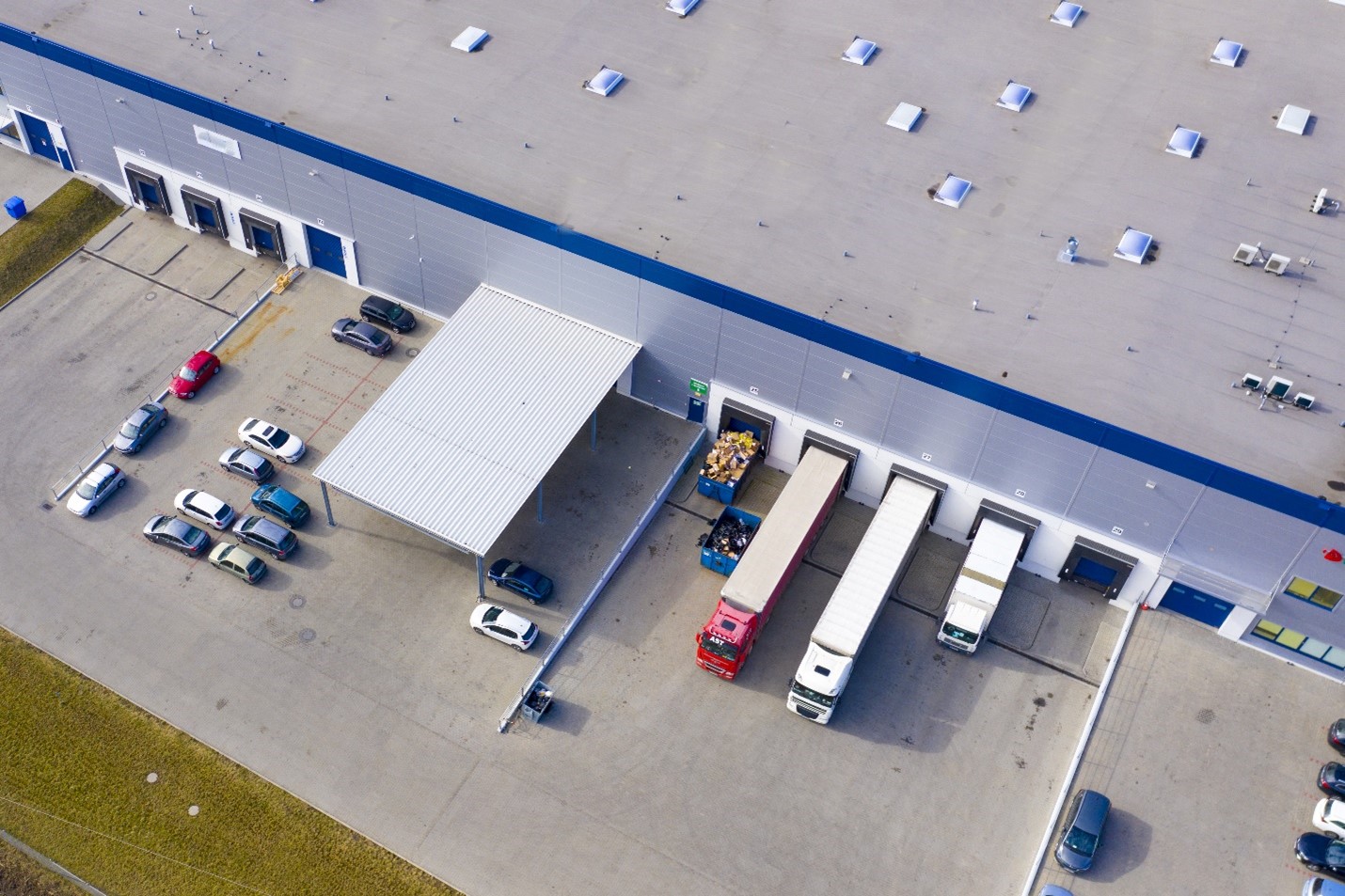 Image of a distribution center with trucks being loaded and unloaded.