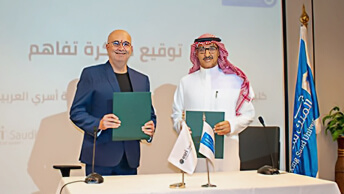 Два человека стоят у стола и держат в руках зеленые папки