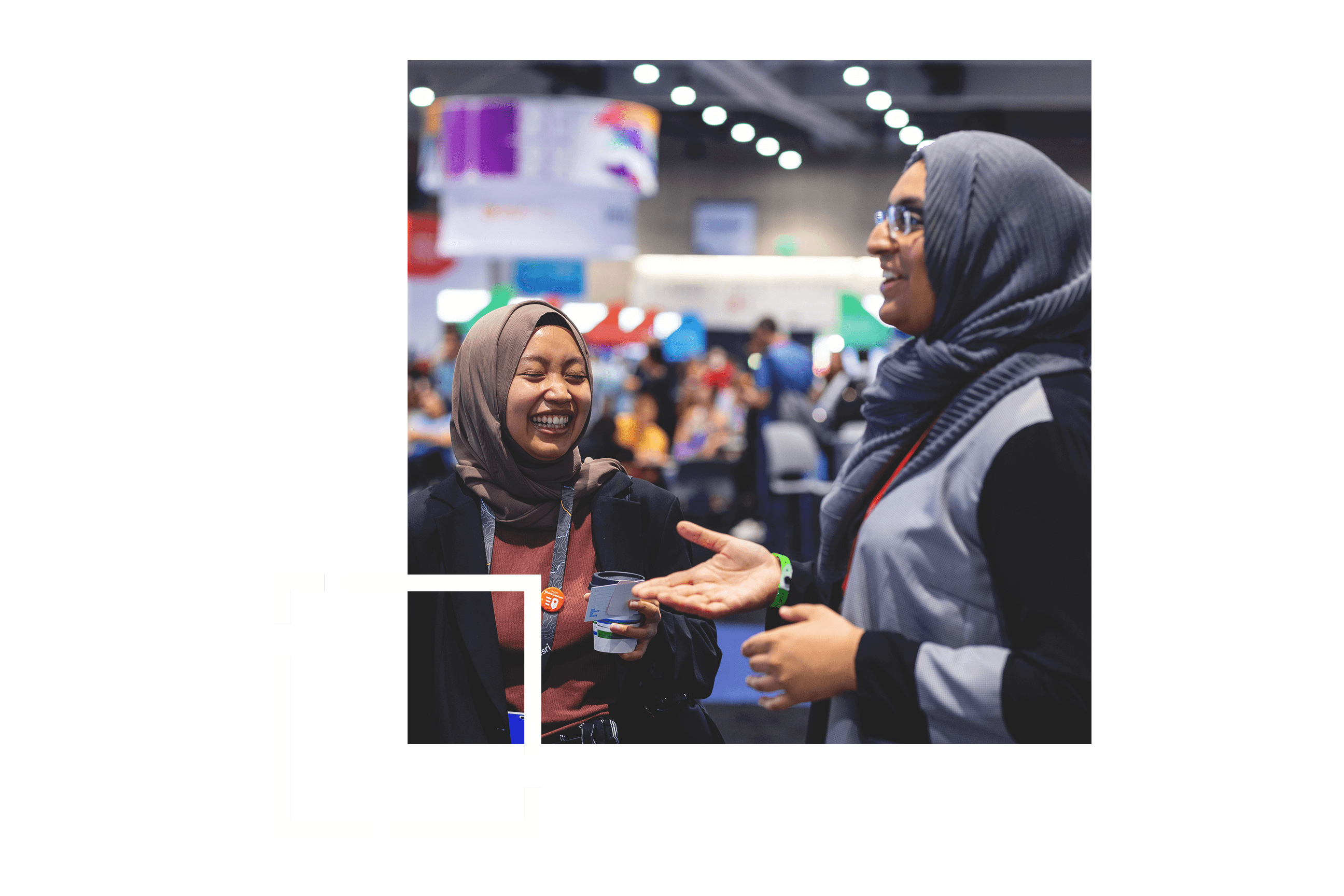 Two people talking and laughing in an exposition hall at a conference