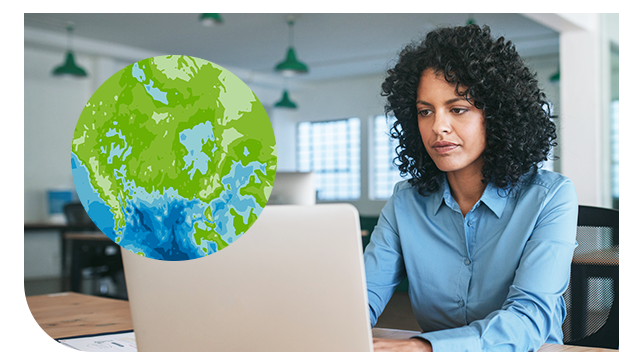 Osoba siedząca w biurze i pracująca na laptopie z nałożoną ilustracją kuli ziemskiej