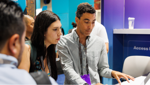 People dressed in business attire gathered at an Expo booth engaged in conversation