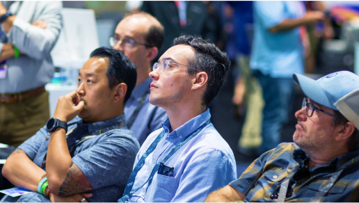 A row of attendees intently watching a presentation in the Expo