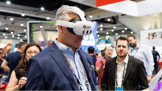 A person wearing a suit tests a virtual reality headset as others watch in the Expo