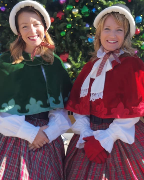 The Desert Carolers dressed in their caroling outfits standing in from of the Christmas tree at Citrus Plaza, Redlands.