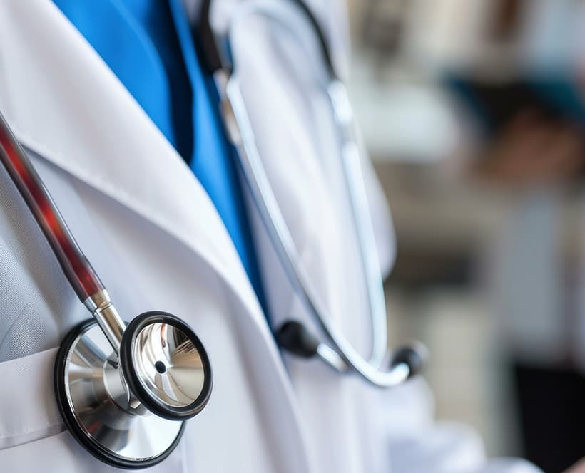 A medical professional wearing a lab coat and a stethoscope around their neck