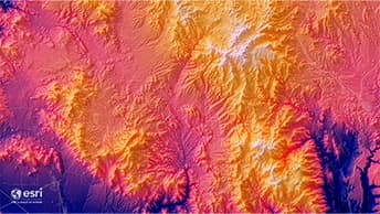 Mountainous terrain in shades of pink, purple, yellow, and orange