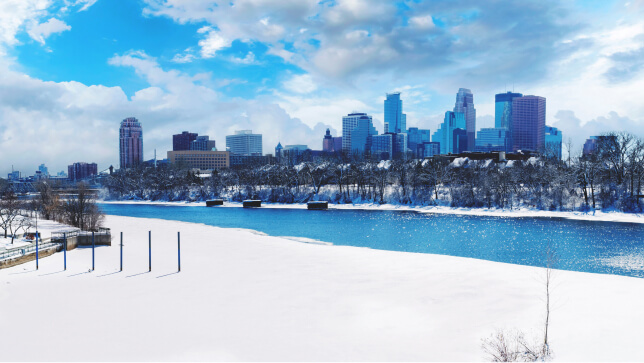 Zdjęcie rzeki Missisipi z zimową panoramą Minneapolis.