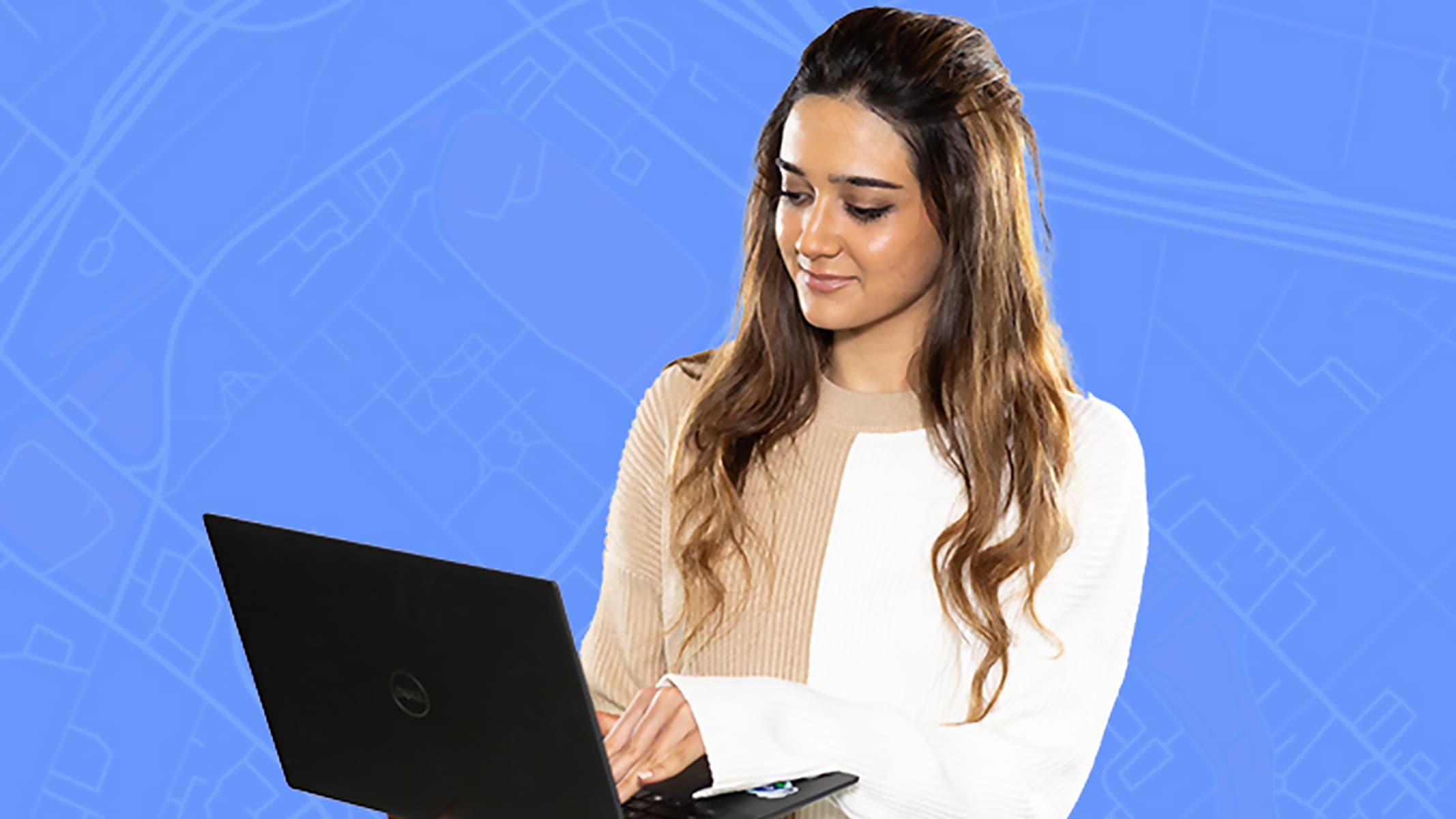 A person wearing beige and white geometric-patterned shirt using a laptop