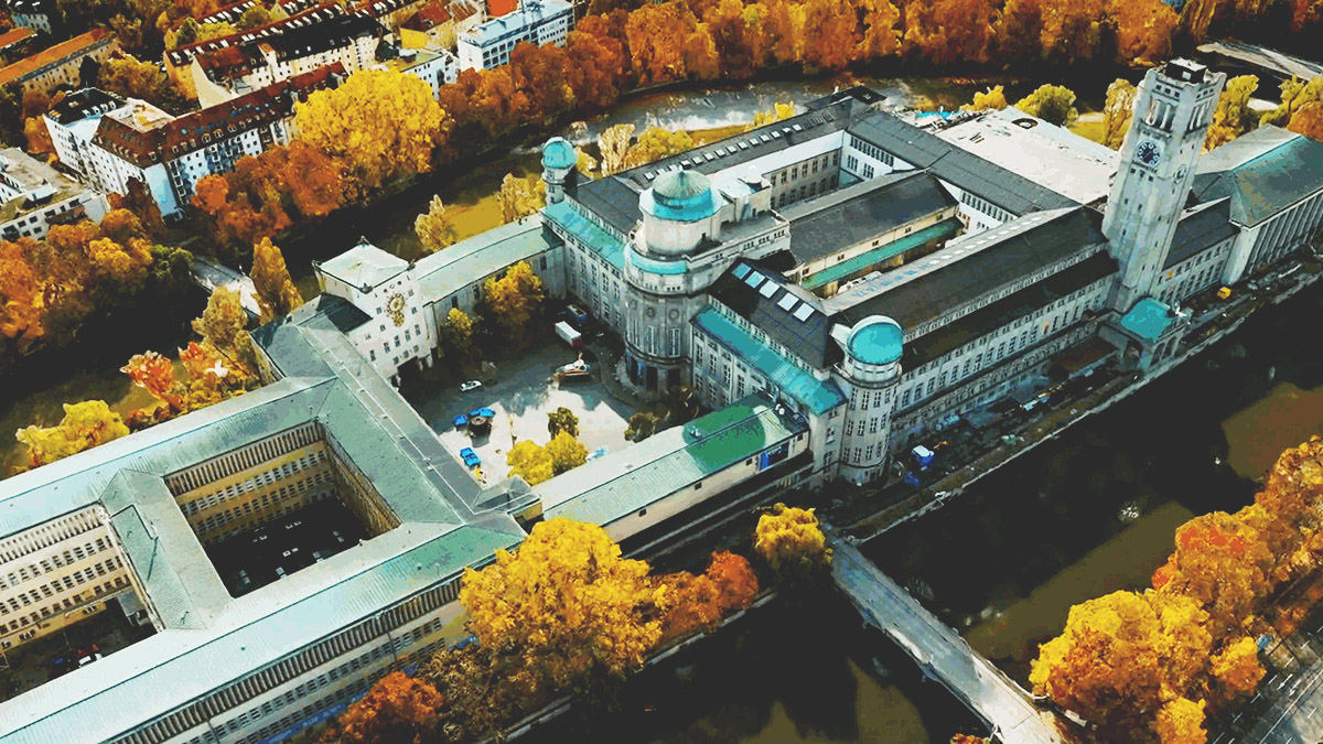 一座大型政府大楼的像底点偏离量影像，周围环绕着黄色和橙色叶子的树木