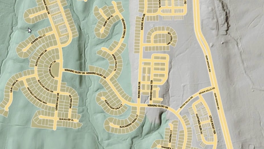 Una vista de arriba a abajo de un área residencial que muestra casas identificadas en recuadros rojos usando aprendizaje profundo para la extracción de entidades