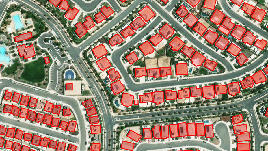 Una vista de arriba a abajo de un área residencial que muestra casas identificadas en recuadros rojos usando aprendizaje profundo para la extracción de entidades