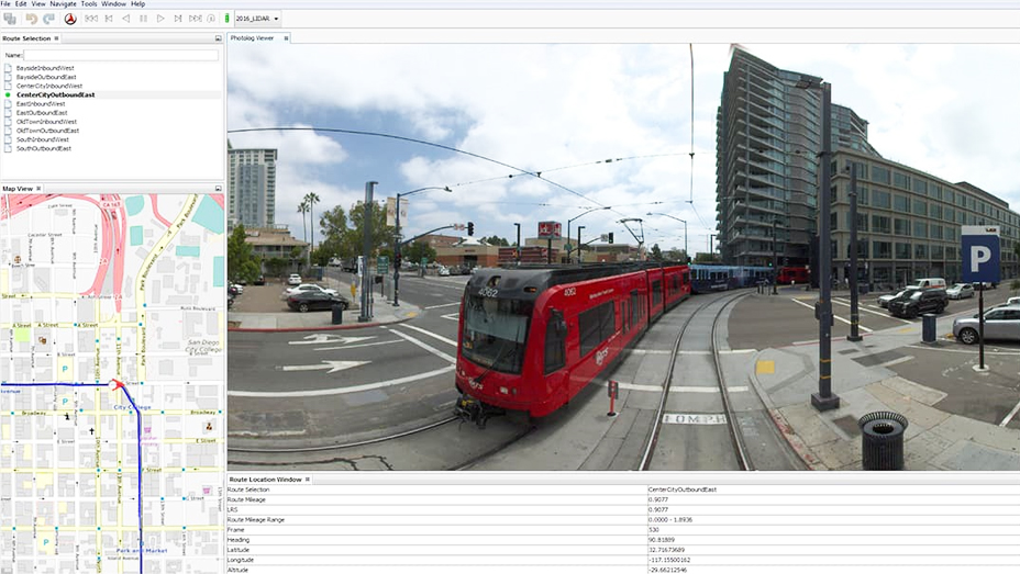 Auf Straßenniveau aufgenommenes Bild einer roten Straßenbahn, daneben eine Karte mit der Fahrtstrecke der Straßenbahn durch die Stadt