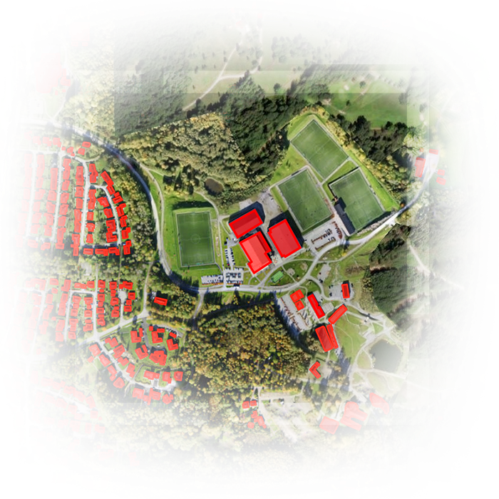 Imagem de satélite de terra com edifícios extraídos coloridos de vermelho e verde, terra e árvores