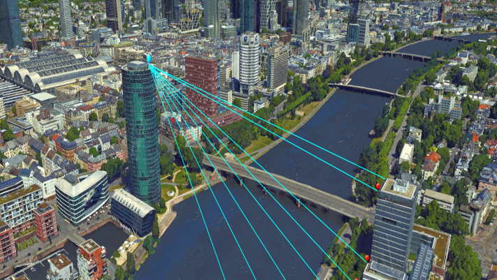 Paisaje urbano con edificios agrupados y un río azul con un edificio alto que emite rayos virtuales azules que cruzan el agua