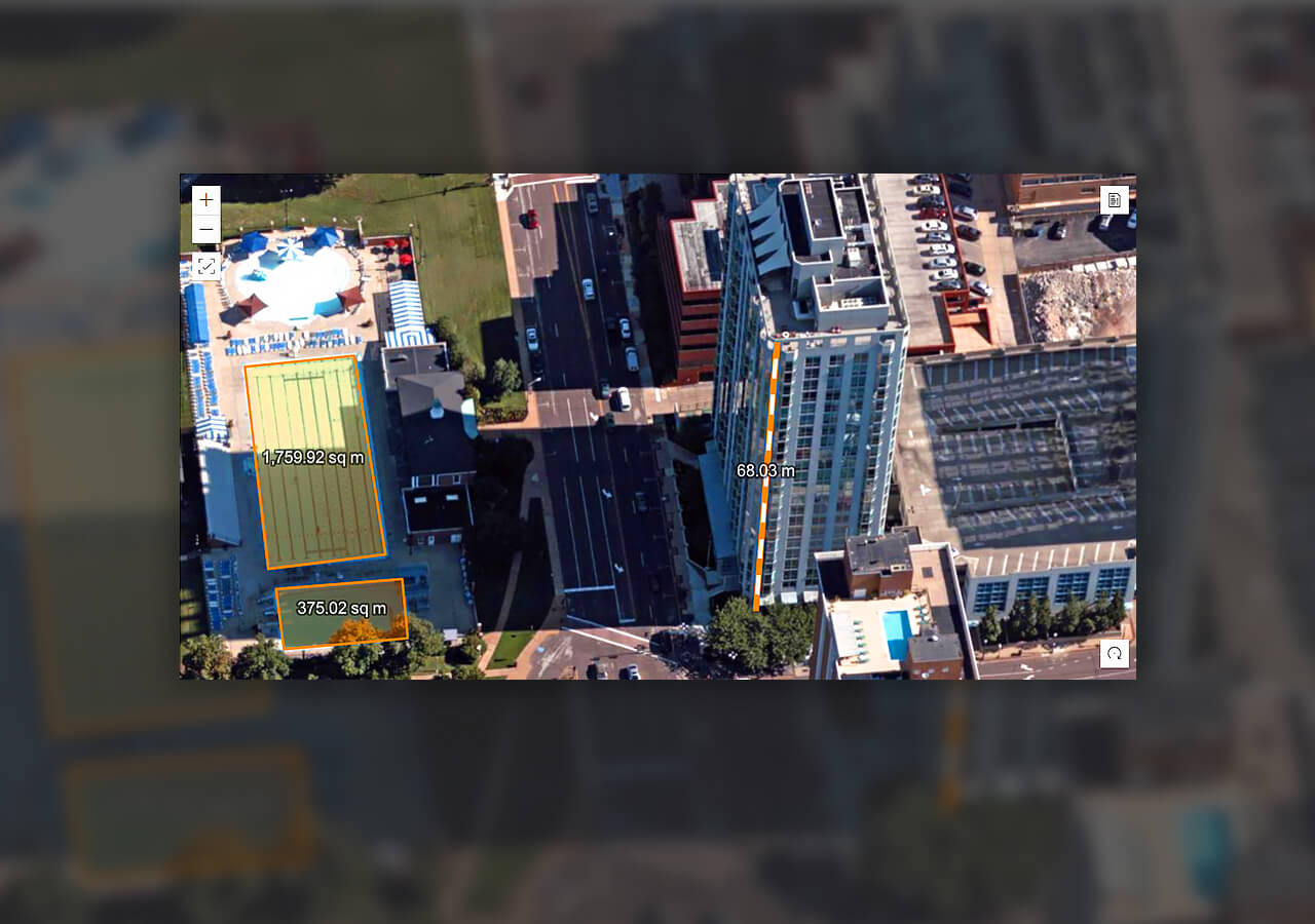 Городская дорога с автомобилями рядом с большим зданием, на которой в ArcGIS Excalibur измеряется здание для строительного проекта