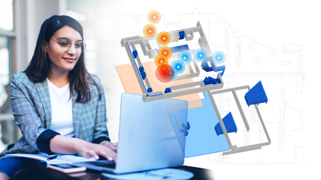 Frau mit Brille, die an einem Laptop arbeitet, auf dem eine digitale Abbildung einer Indoor-Karte mit blauen und orangefarbenen Kreisen zu sehen ist