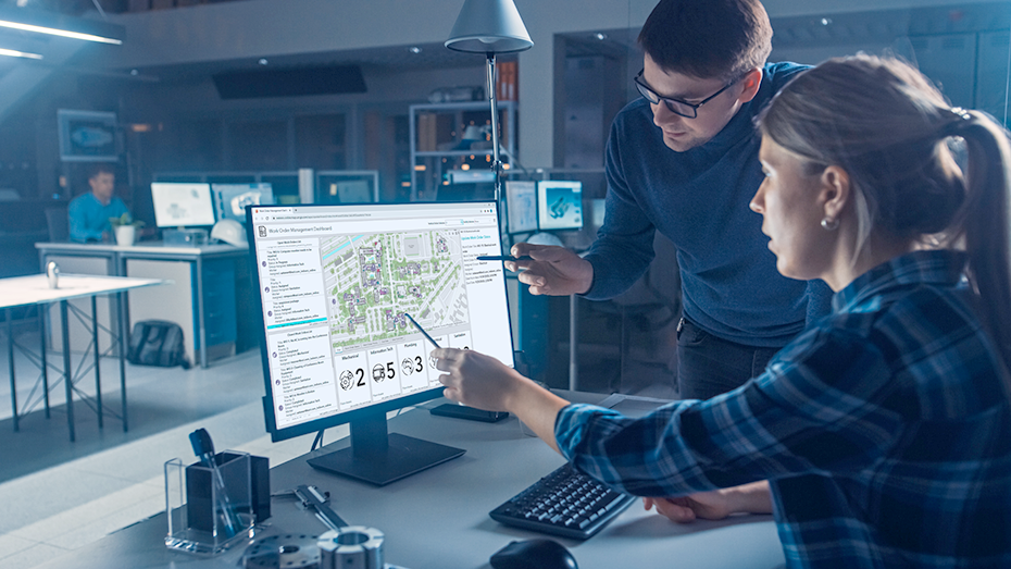 Mężczyzna i kobieta patrzą na ekran komputera wyświetlający panel tworzenia map wnętrz i monitorowania stanu budynku