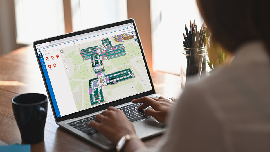 집에서 ArcGIS Indoors를 사용하여 노트북으로 실내 맵의 공간 사용량을 검토하는 사람