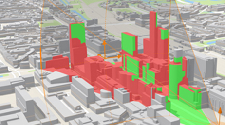 A digital 3D model of a city with multistory buildings shaded in red and green 