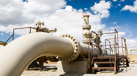 An aboveground utility pipeline under a blue sky with white clouds