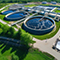 An aerial view of a water treatment center surrounded by a lush, green landscape