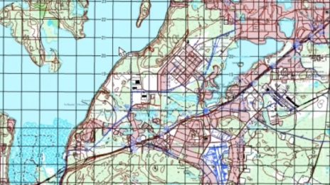 Mapa topograficzna utworzona przy użyciu ArcGIS Production Mapping. Na mapie w powiększeniu wyświetlane są obiekty geograficzne, takie jak drogi, rzeki i punkty zainteresowania.