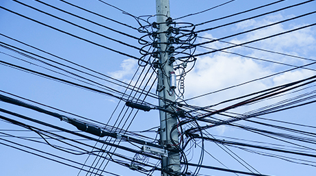 A utility pole connected to dozens of power lines from each direction