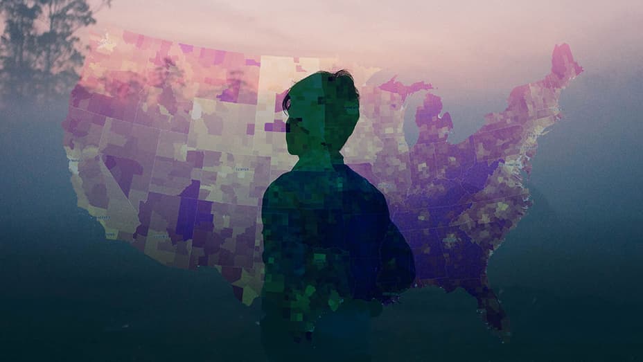 Person silhouetted against a multicolored map of the United States