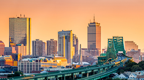 The Boston skyline at golden hour with the Zakim Bridge in the foreground 