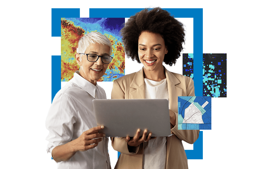 Two women using a computer surrounded by maps