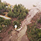 Aerial image of a mudslide surrounded by rubble stretching across a washed-out road