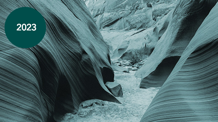 Uma foto de um caminho sinuoso através de uma formação rochosa natural de pedra lisa e estriada em tons de aqua profundo e preto