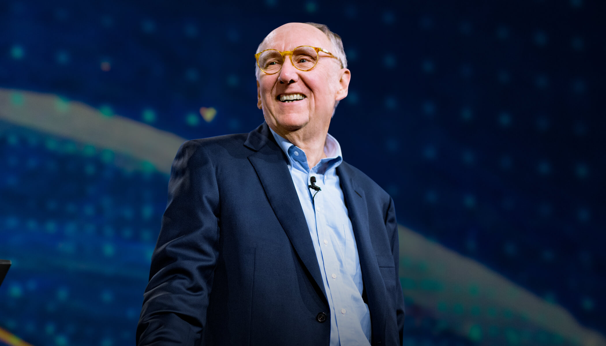 Esri President Jack Dangermond smiling on the Plenary Session stage at the Esri User Conference