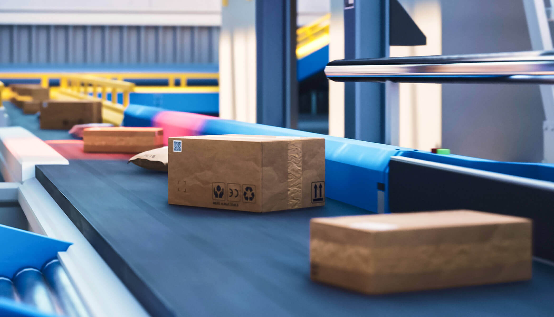A cardboard box marked with a barcode and recycling symbol in transit on a conveyor belt within a warehouse