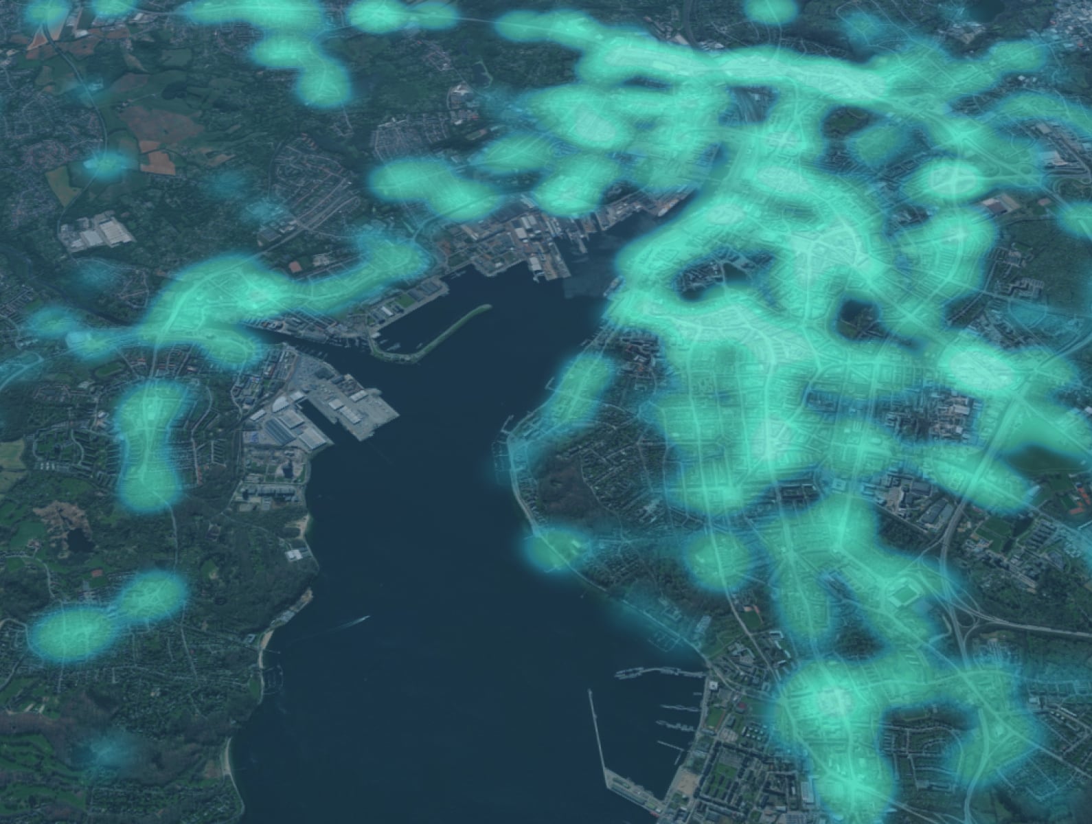 Aerial image of a 3D model of a city spanning both sides of a wide river in blues and greens, overlaid with an out-of-focus layer of glowing green dot clusters