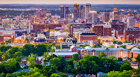 Aerial image of a sprawling city filled with a mix of historic and modern architecture and dotted with green trees