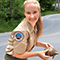 Meredith Martinez smiling while wearing a park ranger uniform and holding a turtle in front of a winding road