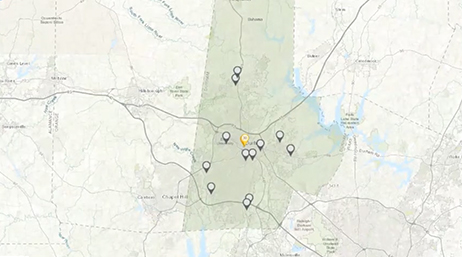 A map of Greenville, North Carolina, with a region shaded in dark transparent green and many dispersed map markers 