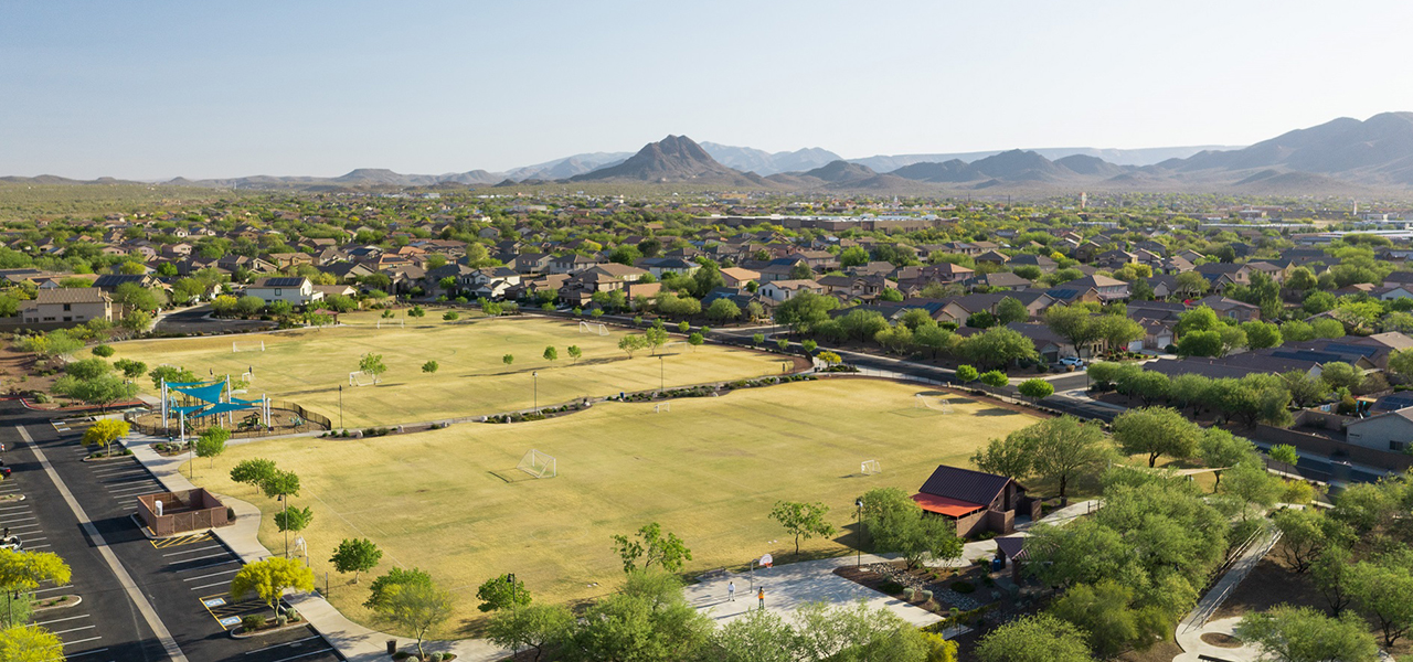 A suburban housing development with a park and soccer fields in a desert city 