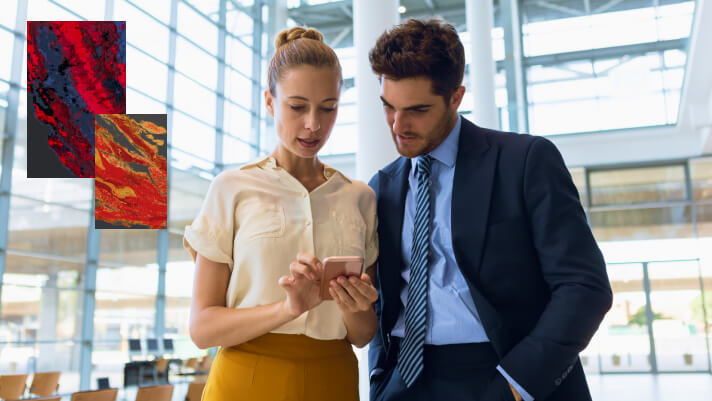 Two people looking at a map on a mobile phone in an office