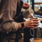 A barista pours milk into a coffee cup